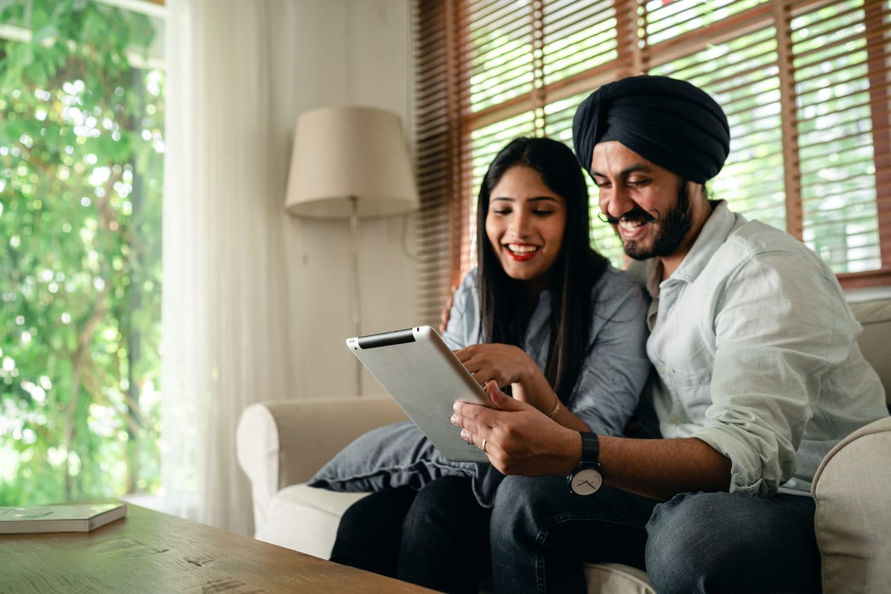 Couple on a sofa looking at a tablet